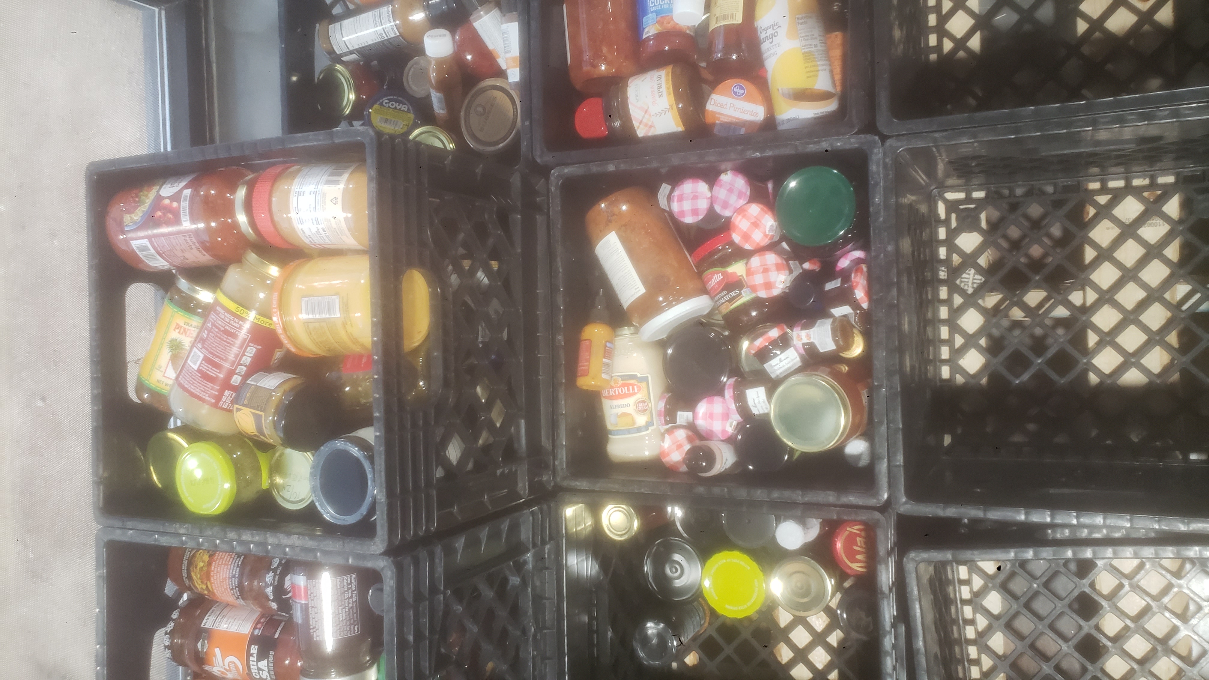 Crates with some filled with glass jars.